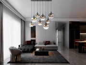 Moderne hanglamp met meerdere glazen bollen, van onderaf gezien in een stijlvolle woonkamer met een grijze bank en tapijt.