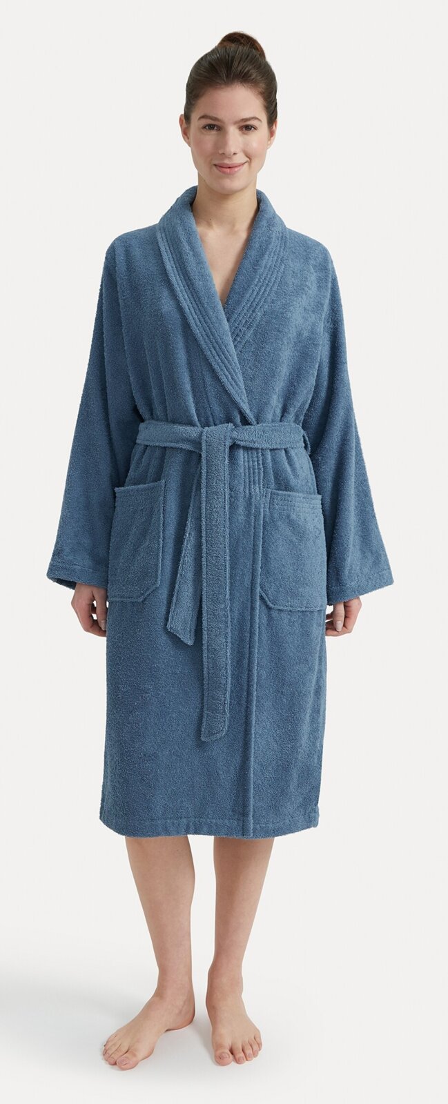 Vrouw in een blauwe badjas met sjaalkraag, vooraanzicht