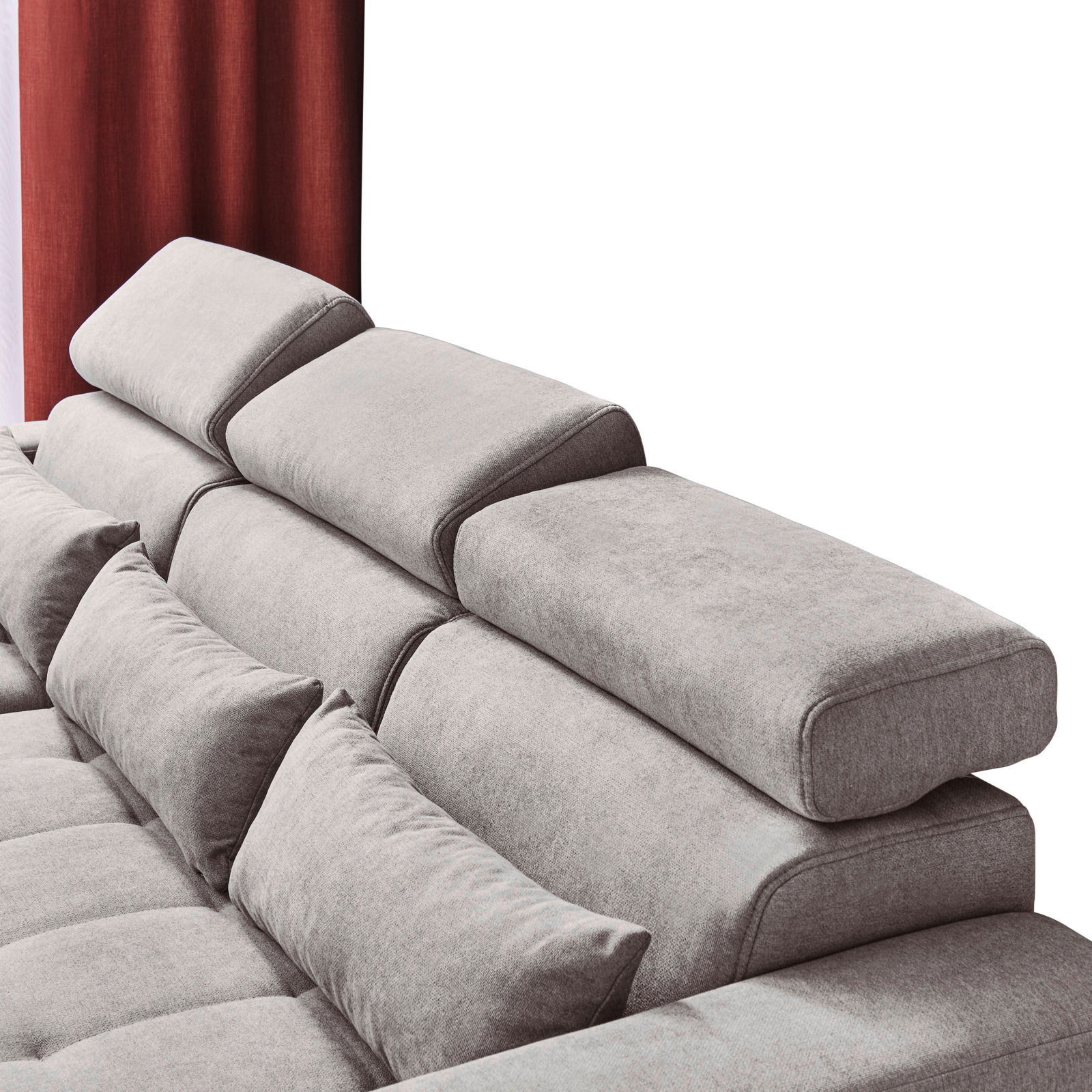 Rückansicht einer grauen Rundecke mit verstellbaren Kopfstützen und roten Vorhängen im Hintergrund.