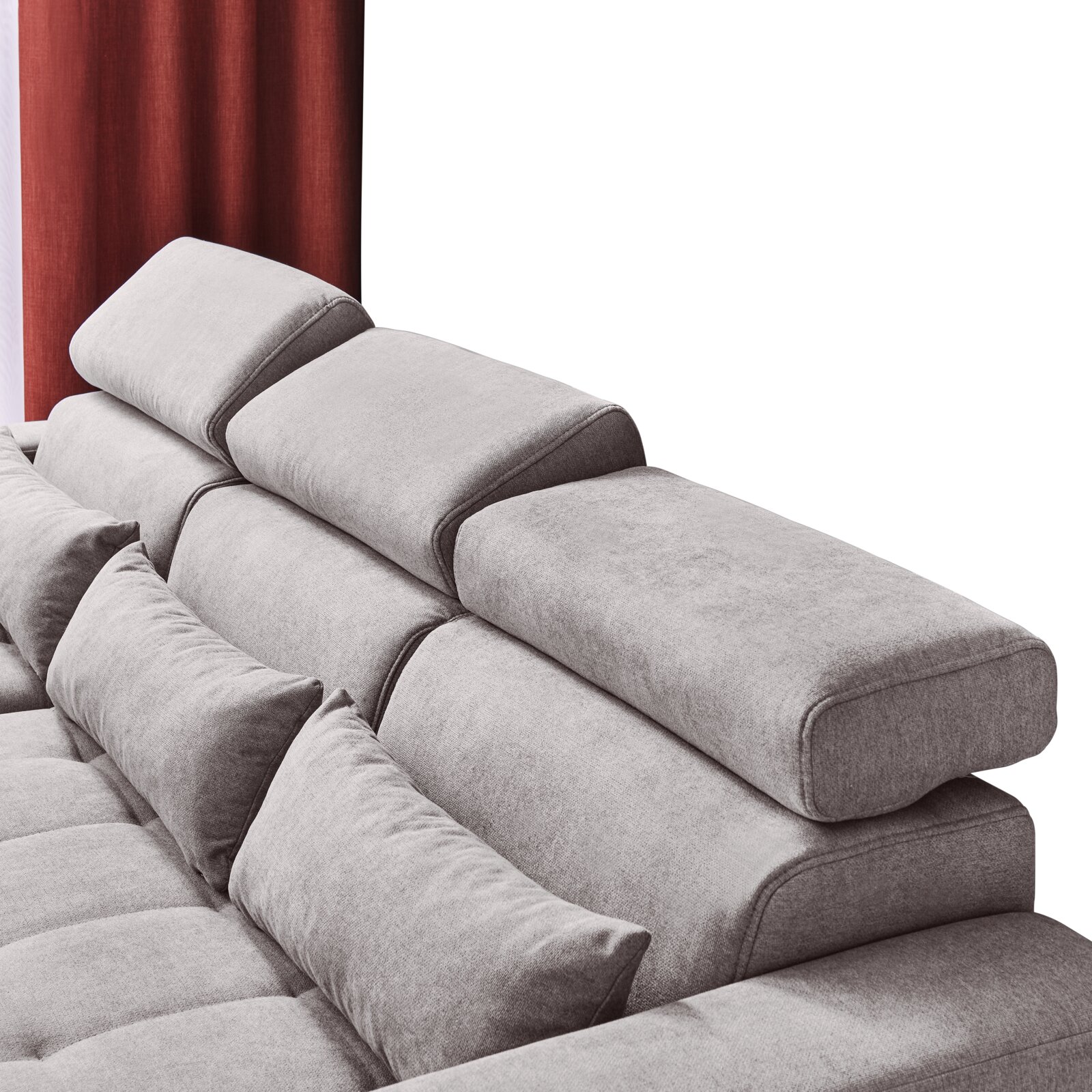 Rückansicht einer grauen Rundecke mit verstellbaren Kopfstützen und roten Vorhängen im Hintergrund.