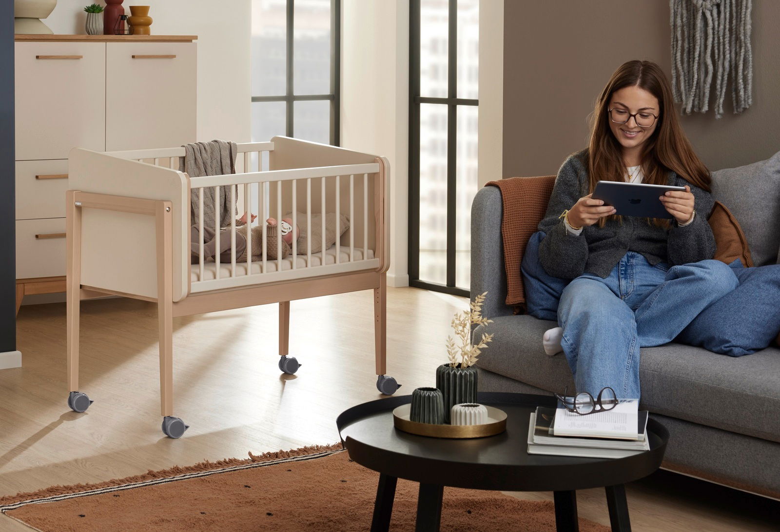 Anstellbett mit Rollen in einem modernen Wohnzimmer, seitliche Perspektive.