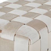 Nahaufnahme einer Hockerbank mit geflochtenem Stoffmuster in Beige- und Cremetönen, aus der Vogelperspektive.