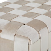 Nahaufnahme einer Hockerbank mit geflochtenem Stoffmuster in Beige- und Cremetönen, aus der Vogelperspektive.