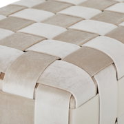 Close-up van een zitbank met een gevlochten patroon in beige- en crèmekleuren, gezien vanuit vogelperspectief.