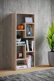 Modernes, schmales Standregal aus hellem Holzdekor mit versetzten Fächern, dekoriert mit Büchern und Vasen, vor Betonwand im Wohnraum, frontal leicht seitliche Perspektive.