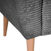 Detailfoto van een grijs, geribbeld gestoffeerd meubel met houten poten, schuin van opzij gezien vanaf de onderkant.