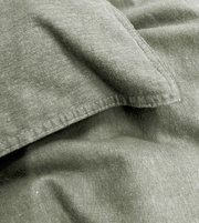 Nahaufnahme von grüner Bettwäsche mit sichtbaren Nähten und Textur