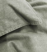 Nahaufnahme von grüner Bettwäsche mit sichtbaren Nähten und Textur