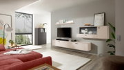 Modernes Wohnzimmer mit wandmontierter TV-Wohnwand in Beige/Creme (Lowboard und Hängeschrank mit Vitrine), Fernseher und Soundbar, aufgenommen in frontaler leicht schräger Perspektive von links.
