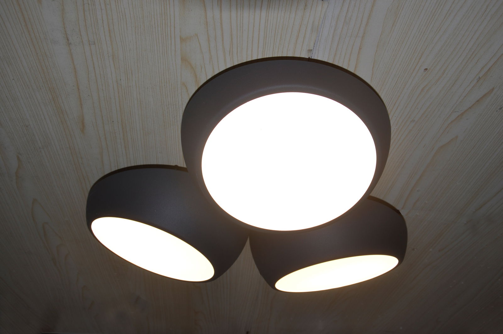 Dreifache LED-Deckenleuchte Bubbles aus schwarzem Metall, von unten betrachtet, an einer Holzdecke montiert.