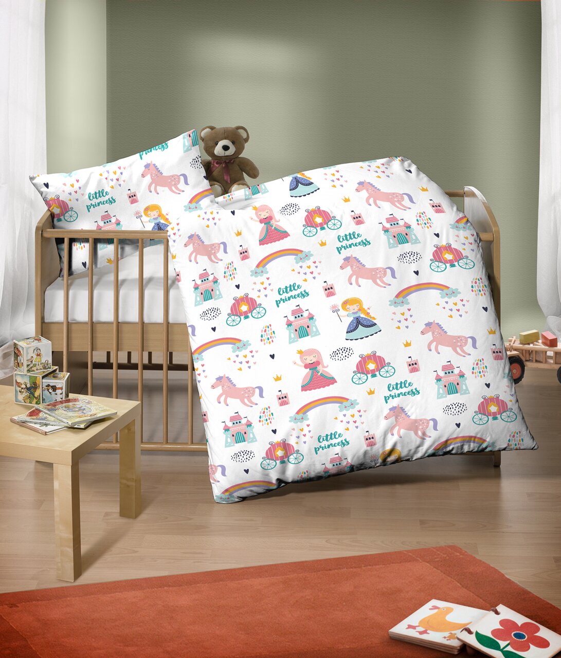 Kinderbettwäsche-Set mit buntem Prinzessinnen- und Einhornmotiv, auf einem Kinderbett arrangiert, mit einem Teddybär als Dekoration.