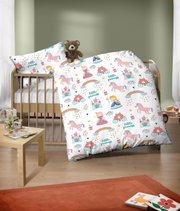 Kinderbettwäsche-Set mit buntem Prinzessinnen- und Einhornmotiv, auf einem Kinderbett arrangiert, mit einem Teddybär als Dekoration.