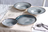 Gourmetteller-Set mit elegantem Design in blauen und grauen Tönen, präsentiert auf einem Tisch mit Tischdecke, aus der Vogelperspektive.