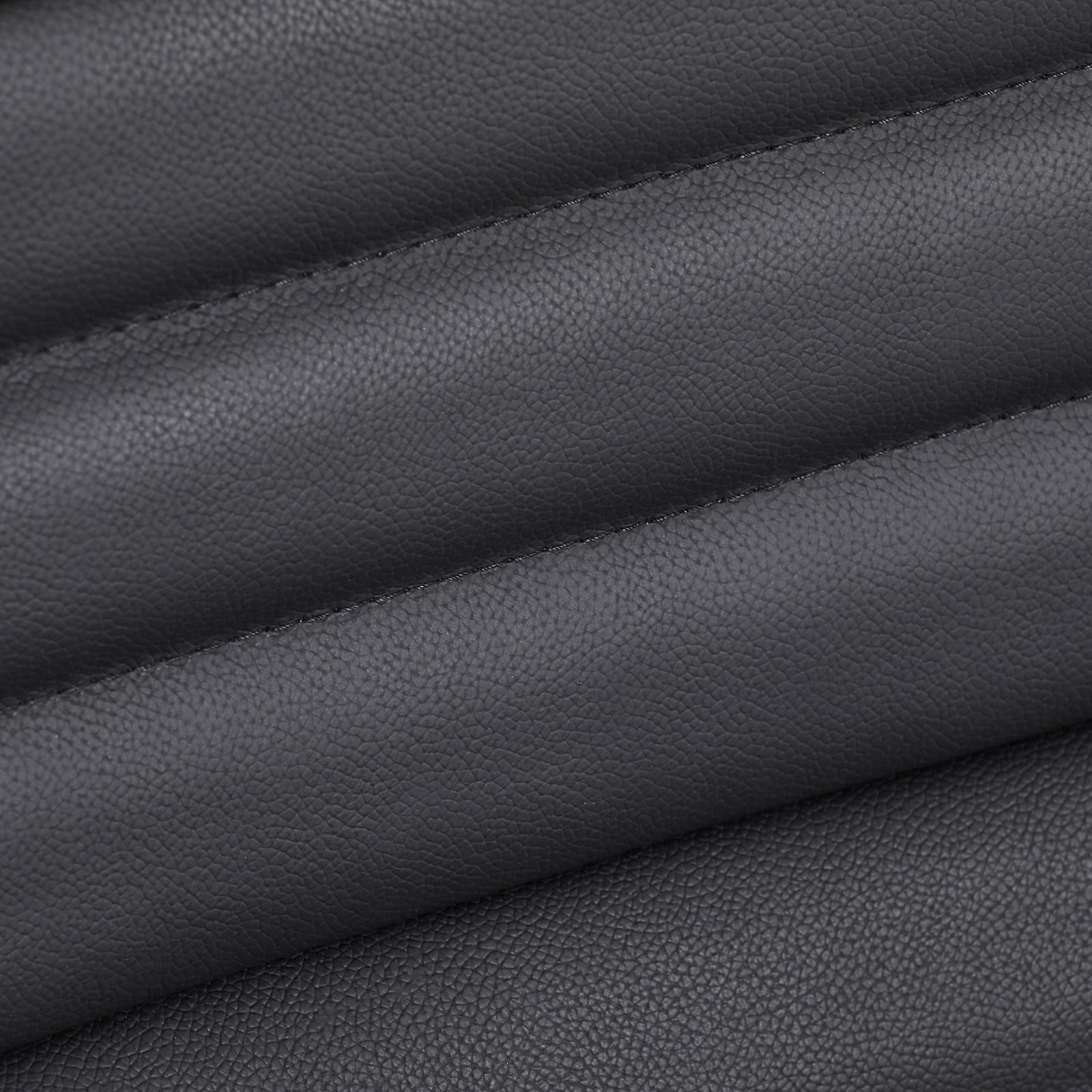 Nahaufnahme der schwarzen Lederpolsterung eines Chefsessels, diagonale Perspektive