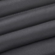 Nahaufnahme der schwarzen Lederpolsterung eines Chefsessels, diagonale Perspektive