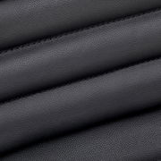 Nahaufnahme der schwarzen Lederpolsterung eines Chefsessels, diagonale Perspektive