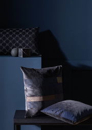 Dunkle Zierkissenhüllen in einem modernen, eleganten Design, präsentiert in einer stilvollen, dunklen Umgebung. Die Perspektive zeigt die Kissen von vorne und leicht seitlich.