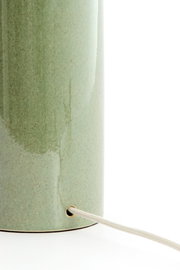 Nahaufnahme eines grünen Lampenfußes mit Kabel, seitliche Perspektive