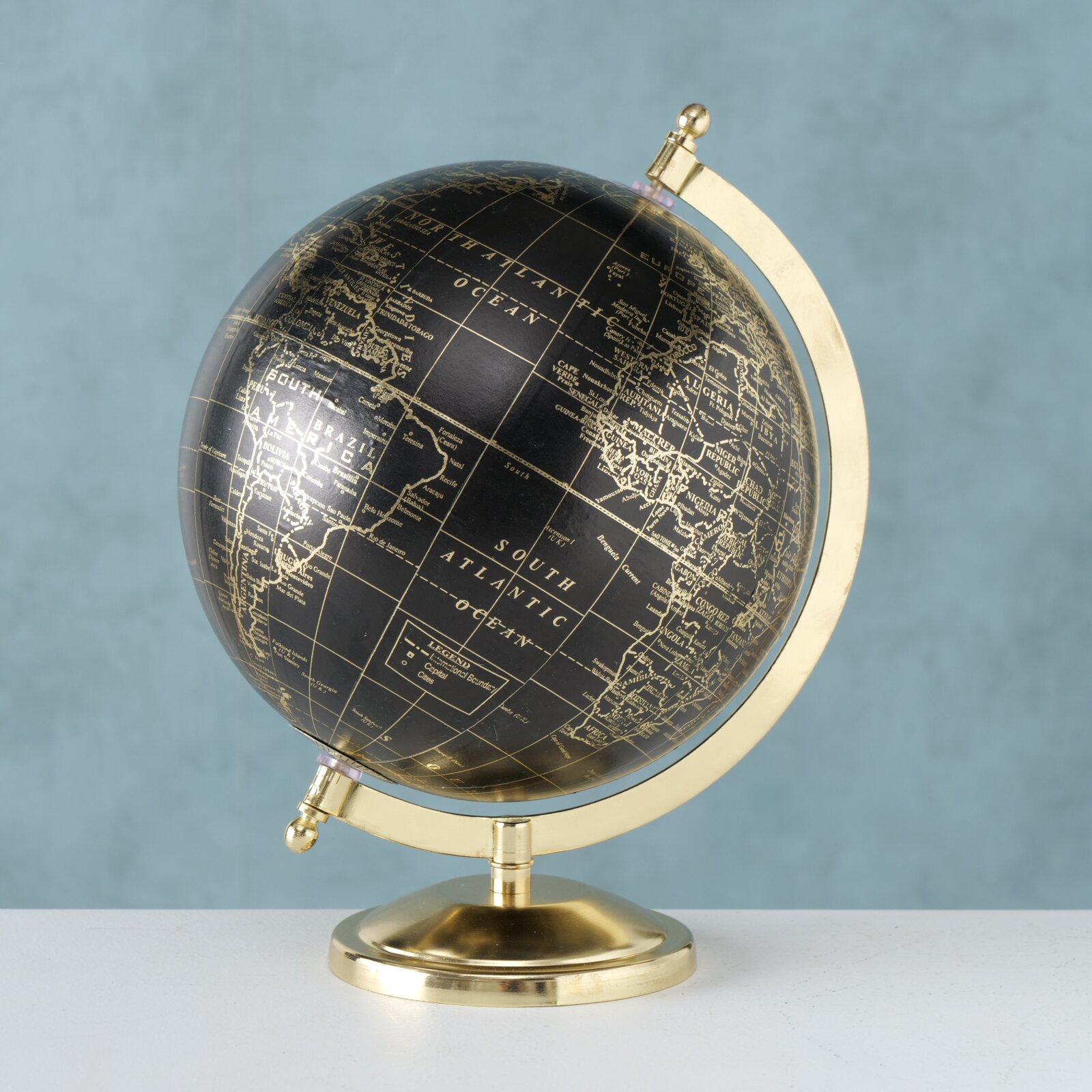Dekorativer Globus mit schwarzem Hintergrund und goldenen Kontinenten, seitliche Perspektive