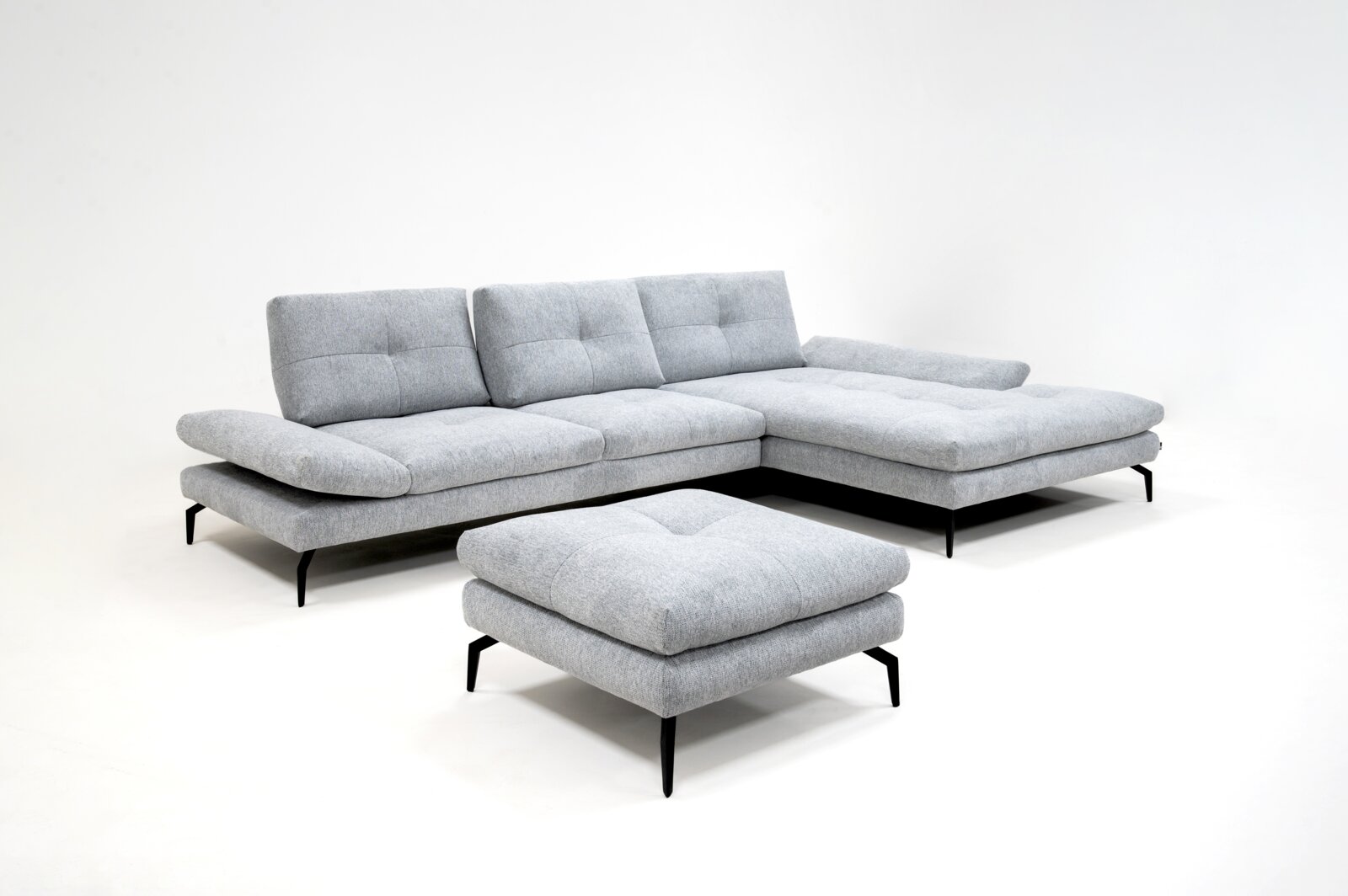 Chilliano Longchairkombination LUGANO Modernes hellgraues Stoff-Ecksofa mit Recamiere rechts, schwarzen Metallfüßen und passendem Hocker, in schräger Vorderansicht auf weißem Hintergrund