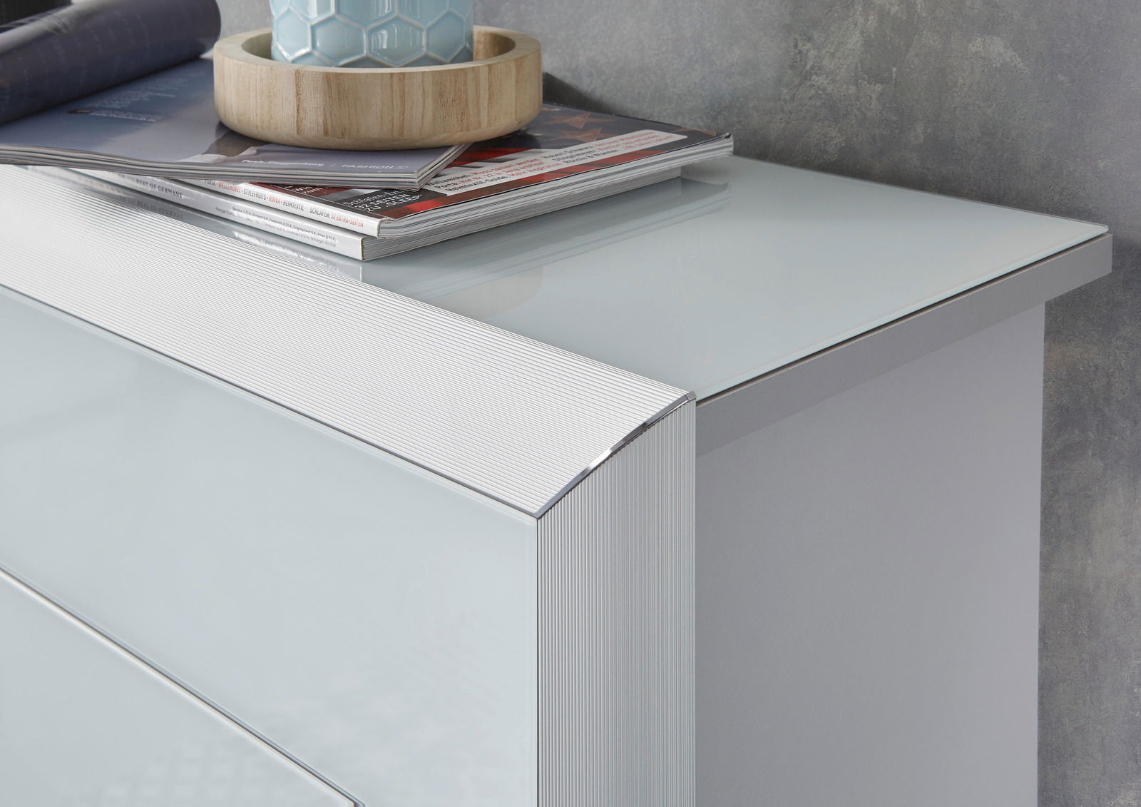 Nahaufnahme eines modernen Schuhschranks mit glänzender Glasoberfläche und eleganten Linien, von oben betrachtet.