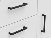 Nahaufnahme einer weißen Kommode mit schwarzen Griffen, seitliche Perspektive