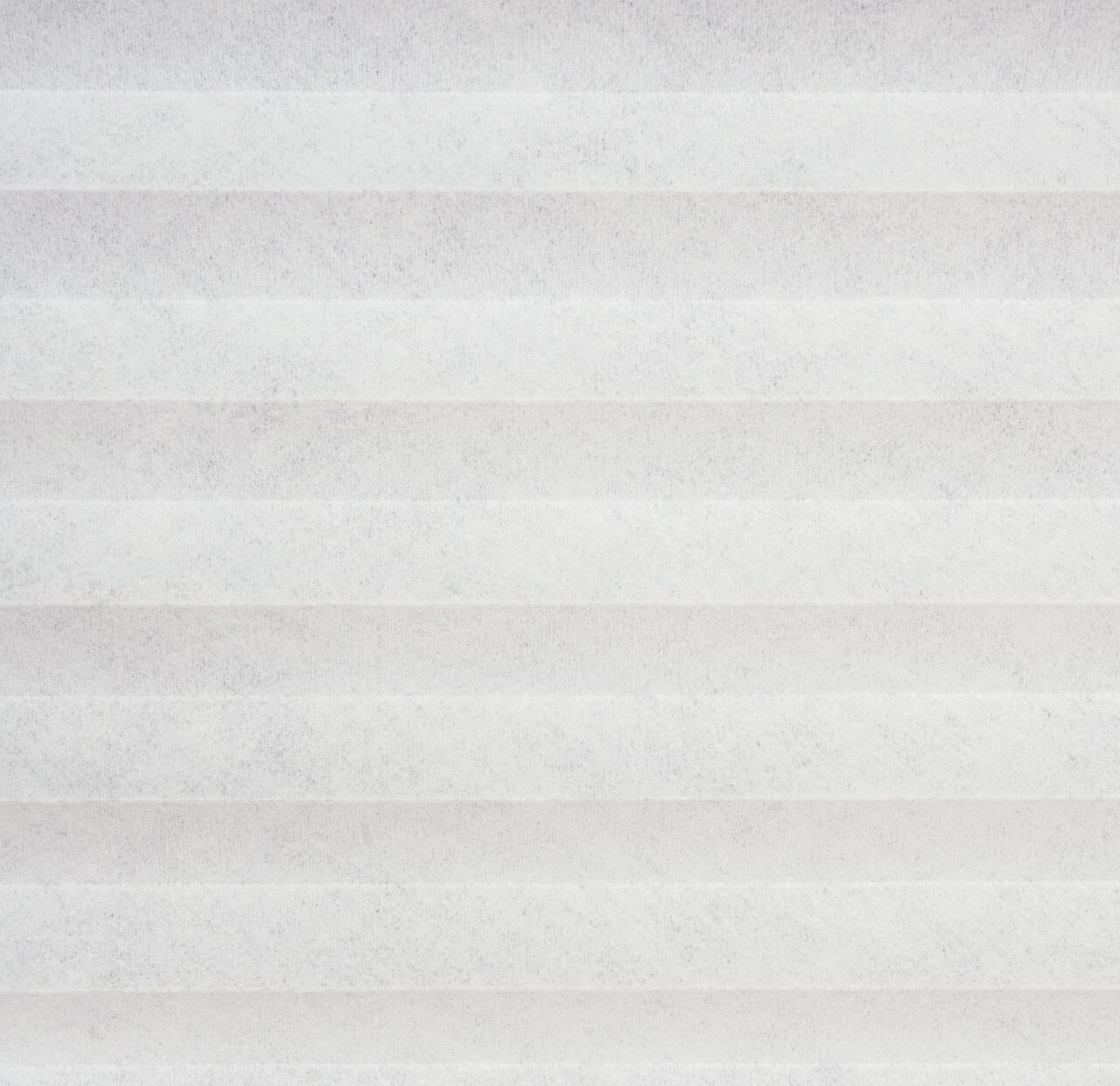 Nahaufnahme eines weißen, gefalteten Plissees in horizontaler Perspektive