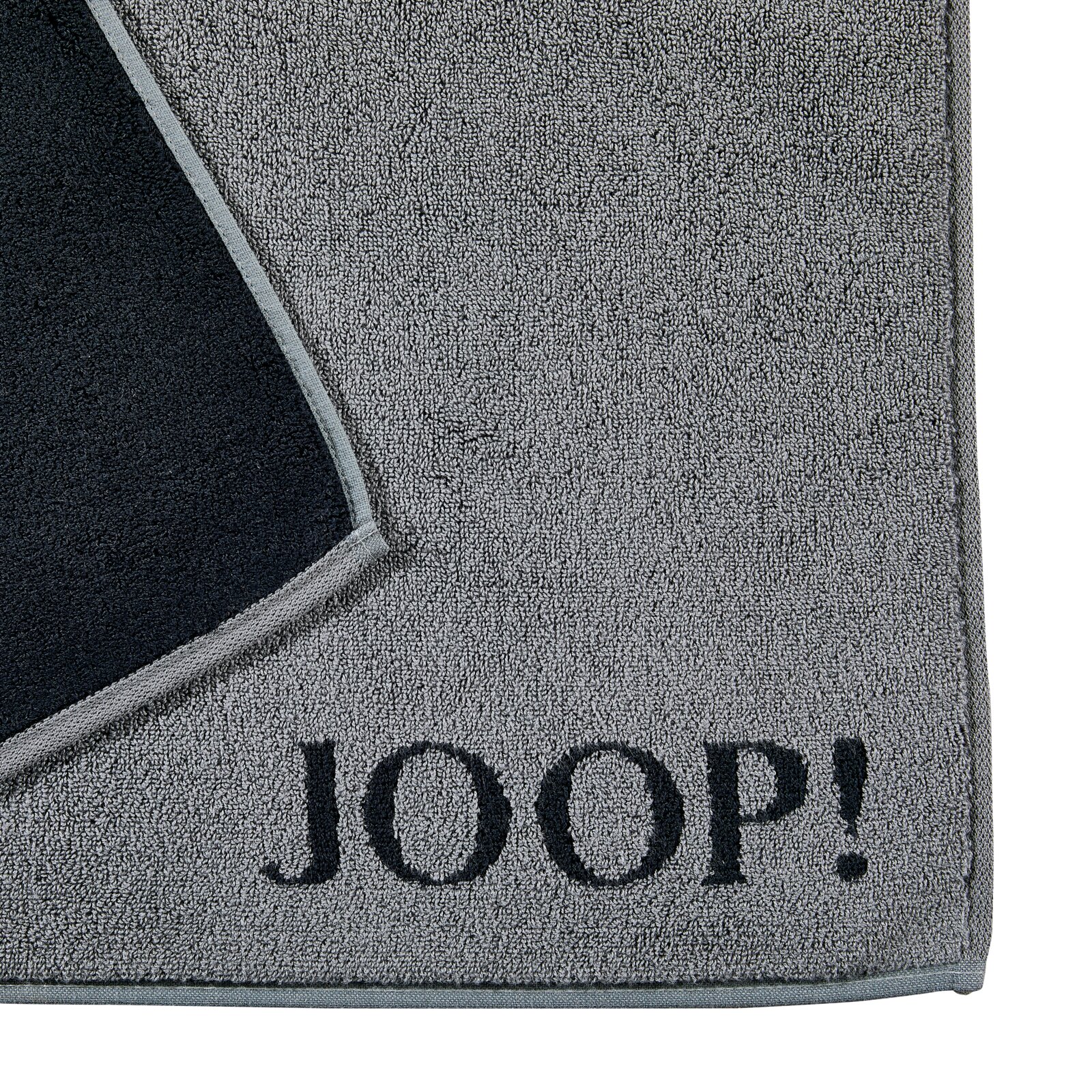 Graue Badematte mit schwarzem Rand und dem Schriftzug 'JOOP!' in der Ecke, von oben betrachtet.