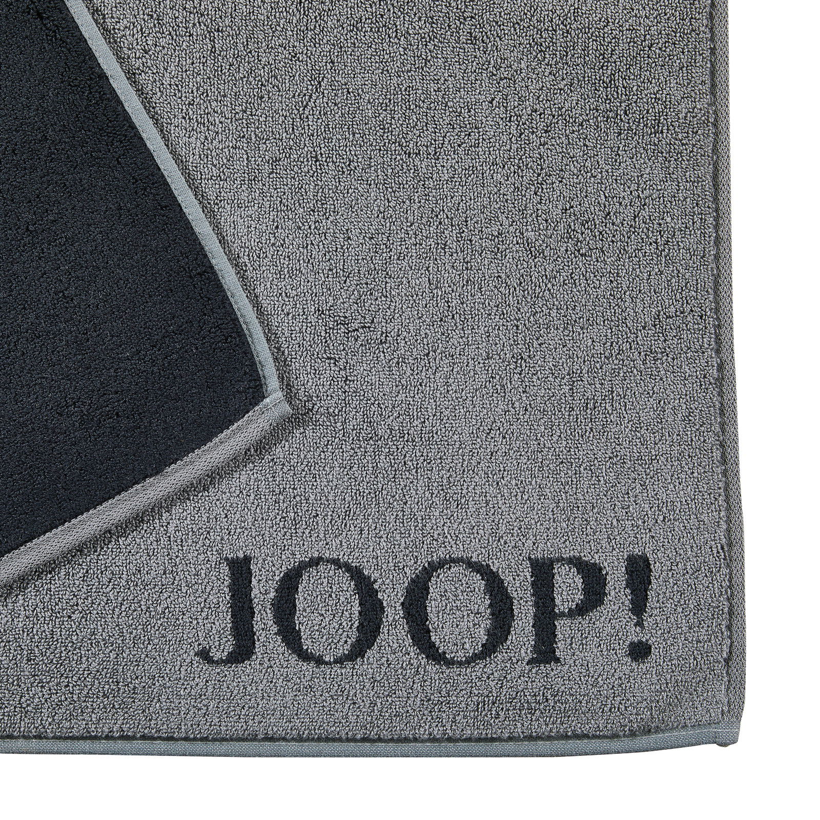 Graue Badematte mit schwarzem Rand und dem Schriftzug 'JOOP!' in der Ecke, von oben betrachtet.