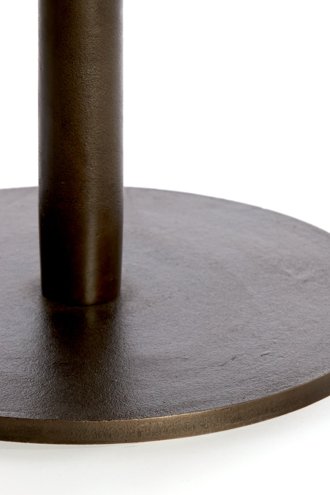 Detailansicht aus leicht erhöhter Perspektive auf einen runden, dunkelbraunen Metallfuß mit senkrechter Säule und strukturierter Oberfläche.