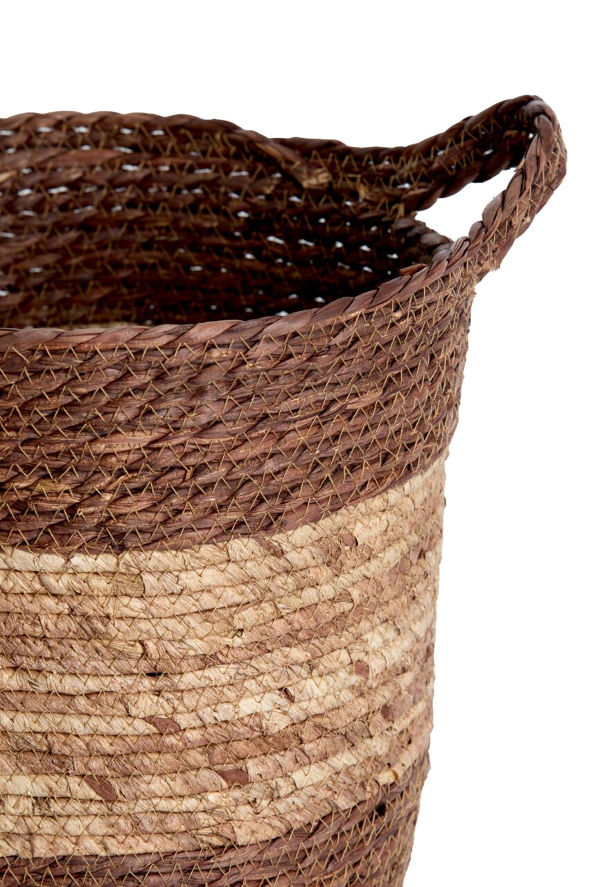 Nahaufnahme eines handgewebten Korbs mit zwei Farben, braun und beige, aus natürlichem Material, seitliche Perspektive.