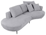 Graues, modernes Sofa mit Ottomane rechts, abgerundeten Ecken und mehreren Kissen, Perspektive von schräg oben.