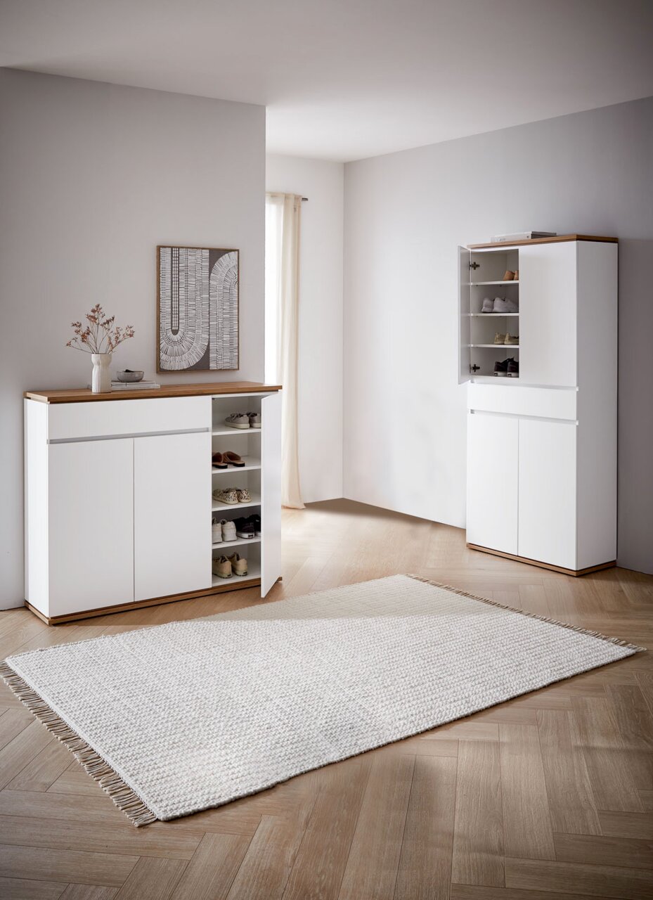 Moderne schoenenkast in wit met houten details; de open deuren geven zicht op verschillende planken met schoenen, gezien vanaf de zijkant.