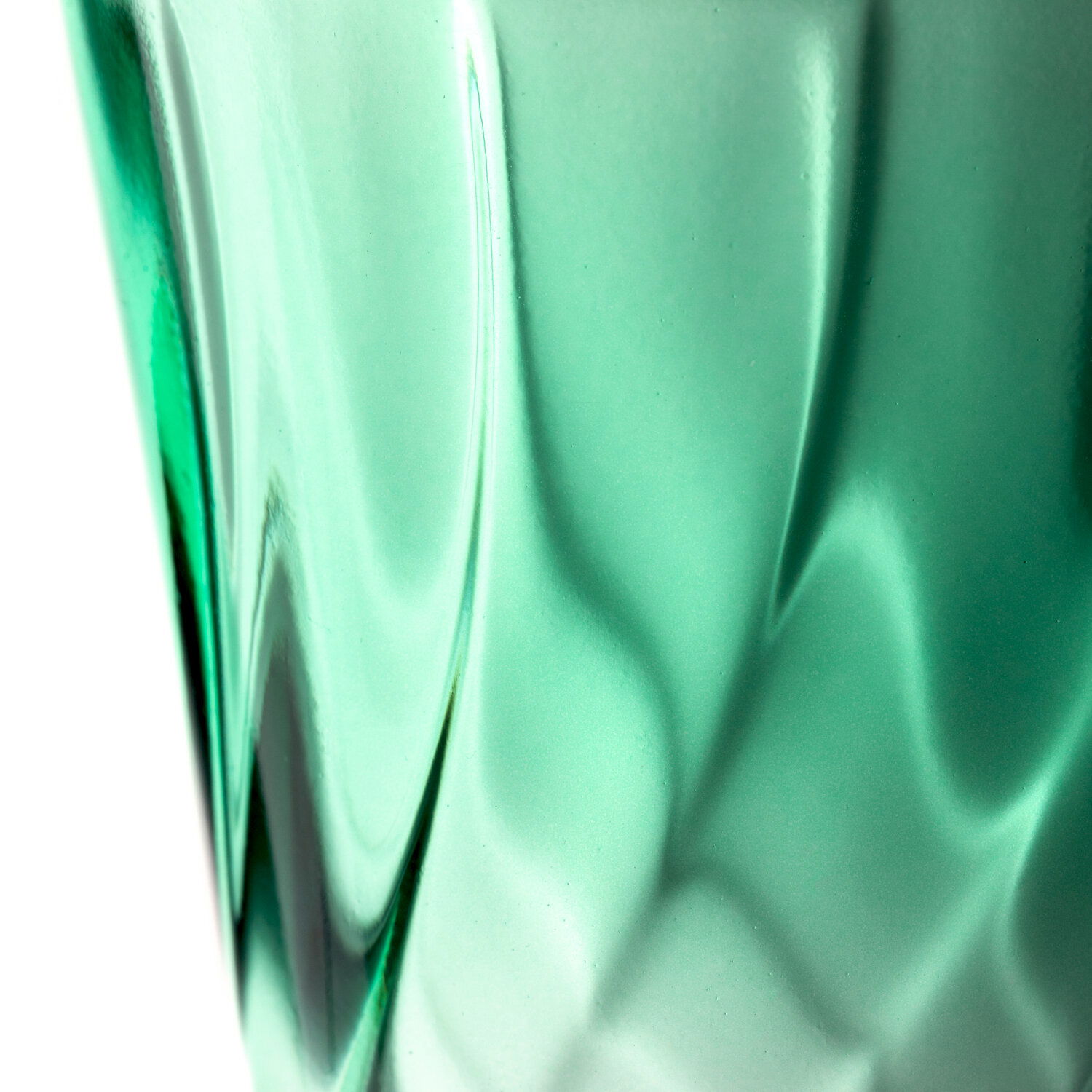 Nahaufnahme eines grünen Trinkglases mit verdrehtem Design, seitliche Perspektive