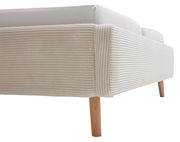 Nahaufnahme eines Polsterbetts mit geripptem, beigem Stoffbezug und Holzbeinen, seitliche Perspektive.