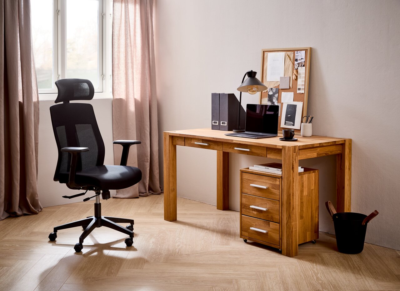 Moderner schwarzer Drehstuhl mit Netzrückenlehne und Kopfstütze, seitliche Perspektive in einem stilvollen Home-Office mit Holzboden und Schreibtisch.