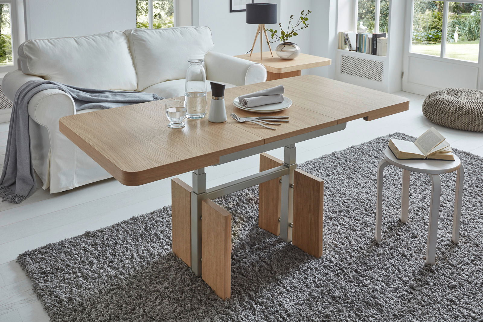 Moderner Couchtisch aus Holz mit Metallgestell in einem hellen Wohnzimmer, seitliche Perspektive.