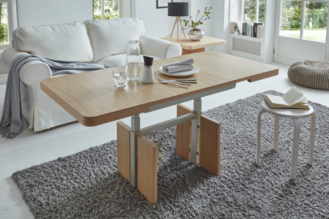 Moderner Couchtisch aus Holz mit Metallgestell in einem hellen Wohnzimmer, seitliche Perspektive.