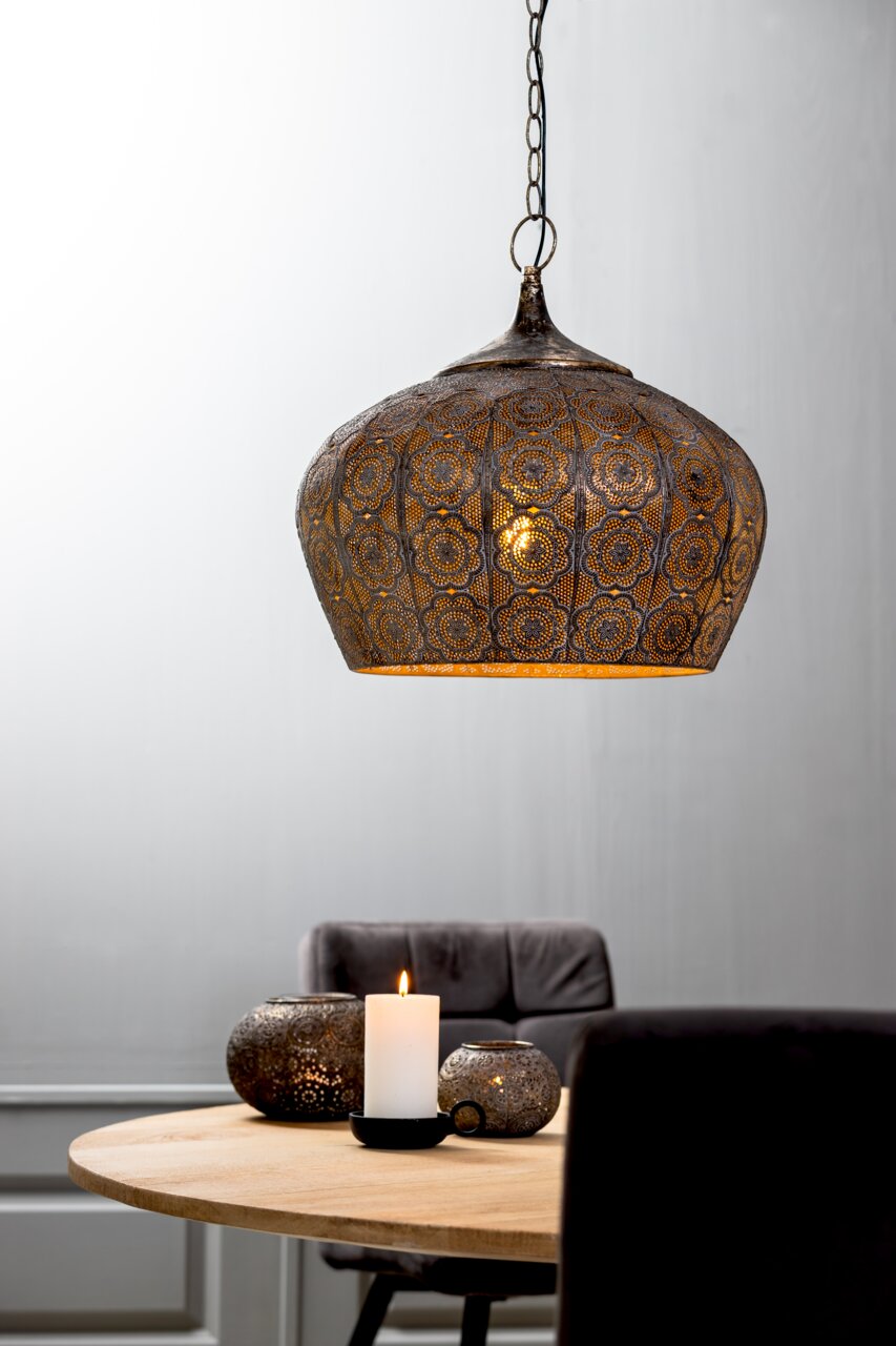 Orientalische Hängeleuchte mit filigranem Muster, seitliche Perspektive, über einem Tisch mit Kerzen und Dekoration.