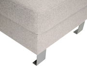 Nahaufnahme eines grauen Hockers mit Metallfüßen, Perspektive von der Seite.