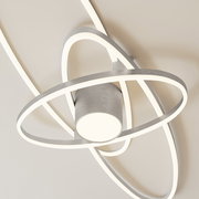 Moderne LED-Deckenleuchte mit drei überlappenden, ringförmigen Lichtbändern in gebürstetem Silber, warmweiß leuchtend, aus schräger Untersicht fotografiert.