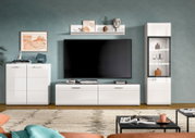 Modernes Wohnzimmer-Set in Weiß mit TV-Lowboard, Sideboard, Vitrine und Wandregal vor blaugrüner Wand, frontal aus Augenhöhe fotografiert