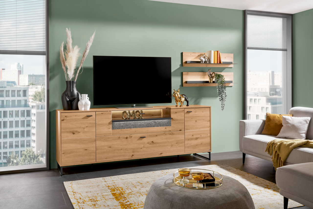 Modernes TV-Lowboard aus Holz mit Dekorationen, frontal fotografiert in einem stilvoll eingerichteten Wohnzimmer.