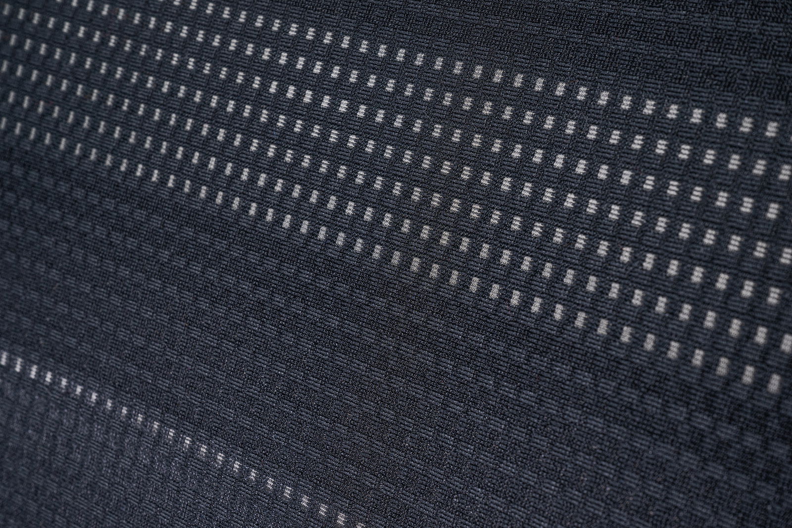 Nahaufnahme des Stoffmusters eines Bürostuhls in diagonaler Perspektive.