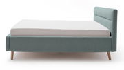 Polsterbett in hellblauem Stoffbezug mit Holzfüßen, seitliche Perspektive