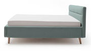 Polsterbett in hellblauem Stoffbezug mit Holzfüßen, seitliche Perspektive