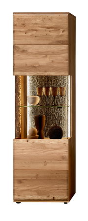 Hohe Vitrine aus massivem Holz in Eiche-Optik mit Glasfach und warm beleuchteter Rückwand, dekoriert mit Gläsern und Schalen, Frontansicht leicht von rechts