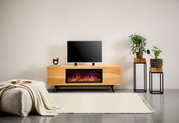 Modernes TV-Lowboard aus hellem Holz mit integriertem Elektrokamin und Flammeneffekt, TV obenauf, frontal aus Augenhöhe im Wohnzimmer-Setting fotografiert.