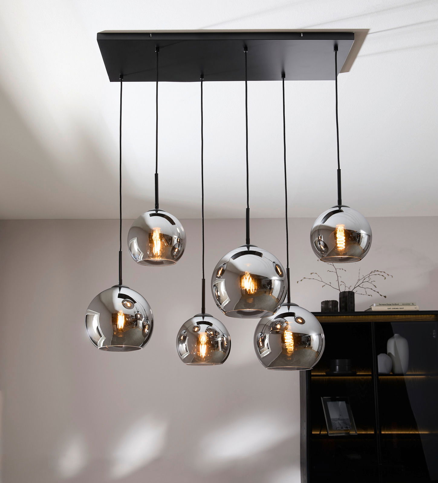 Moderne Hängeleuchte mit sechs kugelförmigen, verspiegelten Lampenschirmen, von unten betrachtet.