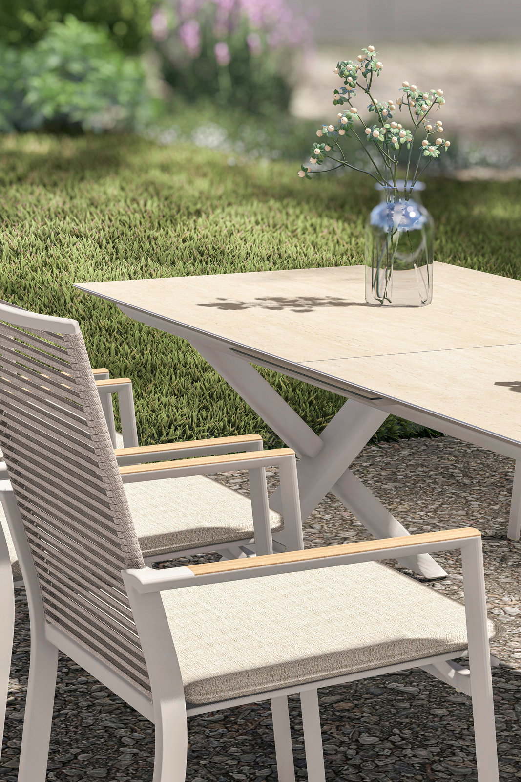 Moderner Gartenstuhl und Ausziehtisch aus hellem Holz und Metall, seitliche Perspektive mit Blick auf eine grüne Gartenlandschaft.